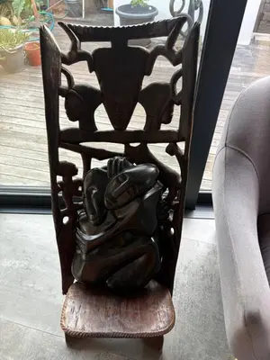 a wooden chair sitting next to a couch at The Modest Mansion in Cape Town