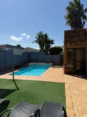 a swimming pool in a yard next to a fence at Hideaway-Poolside Comfort cottage 3km to the Beach in Cape Town