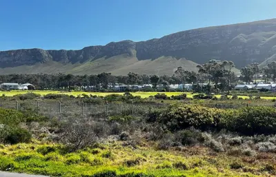a view of a field with mountains in the background at Cali House, Kwaaiwater Getaway in Hermanus
