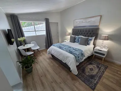 a bedroom with a large bed and a window at SleepINN at Dumont in Paarl