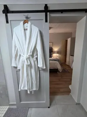 a robe hanging on a door in a bedroom at SleepINN at Dumont in Paarl
