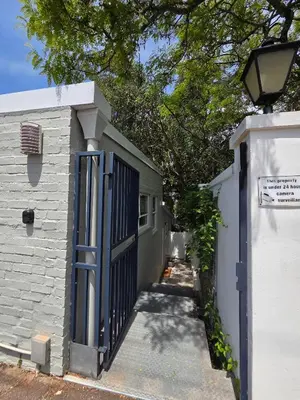 a gate to a white building with a door at SleepINN at Dumont in Paarl