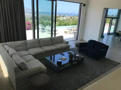 a living room with a couch and a table at Luxury Family Home in Helderberg