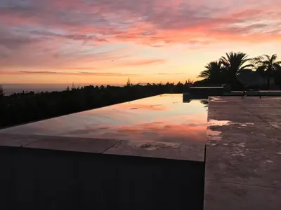 a pool with a sunset in the background at Luxury Family Home in Helderberg