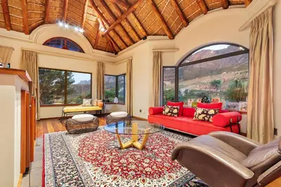 a living room with a red couch and a table at Villa Bezweni in Somerset West