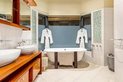 a bathroom with a tub and a sink and a bath tub at Villa Bezweni in Somerset West