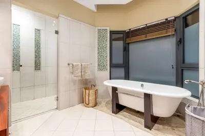 a bathroom with a tub and a shower at Villa Bezweni in Somerset West