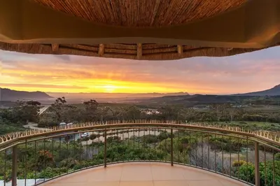 a view from the balcony of a house with a sunset at Villa Bezweni in Somerset West