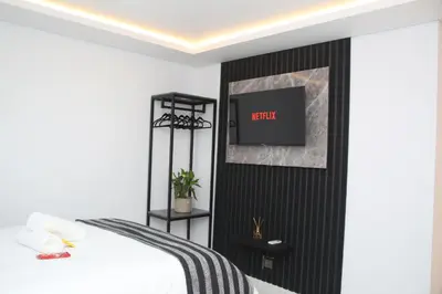 a bedroom with a bed and a tv on a wall at Willow Brooks in Cape Town