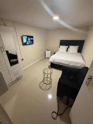 a bedroom with a bed and a tv on the wall at Joy House in Cape Town