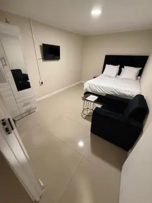 a bedroom with a bed and a couch and a television at Joy House in Cape Town