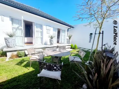 a patio with chairs and a table in a yard at LaPlace in Strand