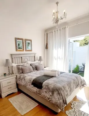 a bedroom with a bed with a chandelier and a window at LaPlace in Strand