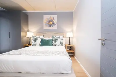 a bedroom with a white bed with green pillows at 410 Riverlands - Lux 1 bedroom Apartment in Cape Town