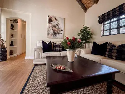 a living room with a couch and a coffee table at AFRICA WILD HERMANUS Luxury Self Catering Accommodation in Hermanus