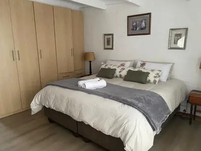 a bedroom with a large bed with two towels on it at Skurwejantjie in Hermanus