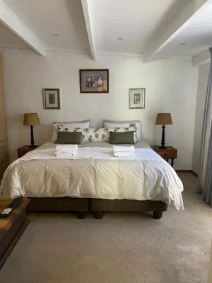 a bedroom with a large bed and two lamps at Skurwejantjie in Hermanus