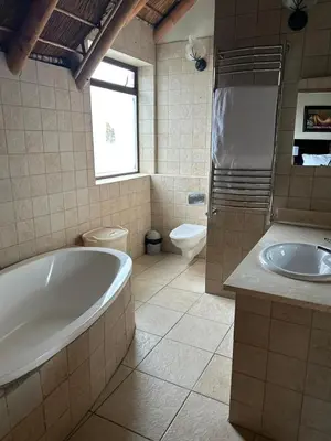 a bathroom with a tub and a toilet and a sink at Daisy Accomodation and Spa 5 Bed all private en-suite in Cape Town