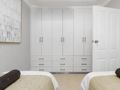 a white bedroom with two beds and white cabinets at Sandy Shores On Beach - 709 in Strand