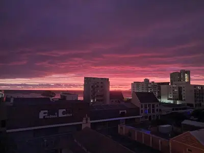 a city skyline at sunset with a red sky at Panorama Sea and Mountain Views in Strand