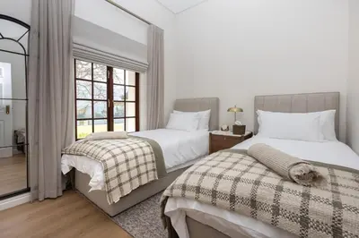 two beds in a bedroom with a window at Villa Canetsfontein in Wellington