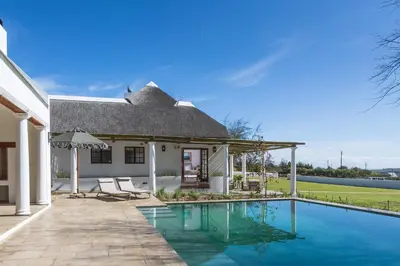 a home with a swimming pool and a house at Villa Canetsfontein in Wellington