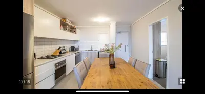 a kitchen with a wooden table with a vase of flowers on it at Waters Edge Sanctuary in Cape Town