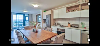 a kitchen with a wooden table and chairs in it at Waters Edge Sanctuary in Cape Town