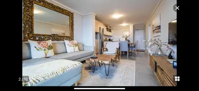 a living room with a couch and a mirror at Waters Edge Sanctuary in Cape Town