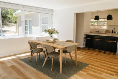 a kitchen and dining room with a wooden table and chairs at Patryssenvalleij Farm and Cottages in Stellenbosch
