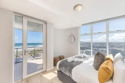 a bedroom with a bed with a view of the ocean at Horizon Bay 303-Oceanfront Apt on Kite Beach with Balcony & Pool in Cape Town