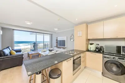 a kitchen with a view of the ocean at Horizon Bay 303-Oceanfront Apt on Kite Beach with Balcony & Pool in Cape Town