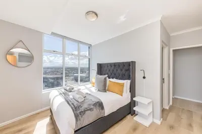 a bedroom with a large bed with a large window at Horizon Bay 303-Oceanfront Apt on Kite Beach with Balcony & Pool in Cape Town