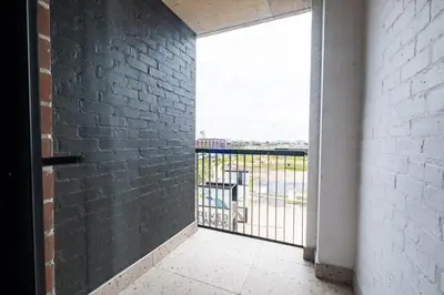 an empty room with a balcony with a brick wall at 309 Riverlands - Lux 1 Bedroom Apartment in Cape Town