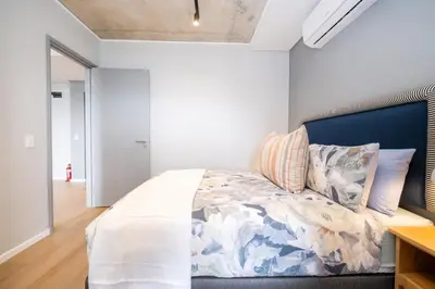 a bedroom with a bed with a blue headboard at 309 Riverlands - Lux 1 Bedroom Apartment in Cape Town