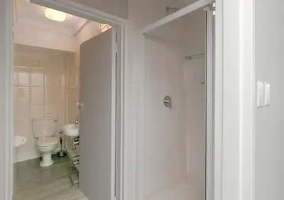 a bathroom with a toilet and a shower with a glass door at 706 Odeon Towers - Ocean Splendour in Strand