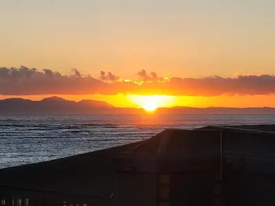 a sunset over the ocean with mountains in the distance at 706 Odeon Towers - Ocean Splendour in Strand