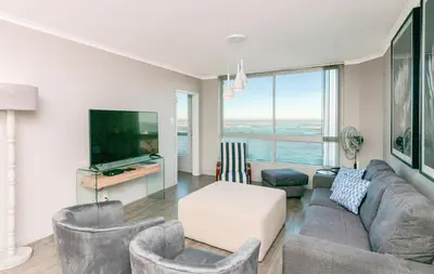 a living room with a couch and chairs and a tv at 706 Odeon Towers - Ocean Splendour in Strand