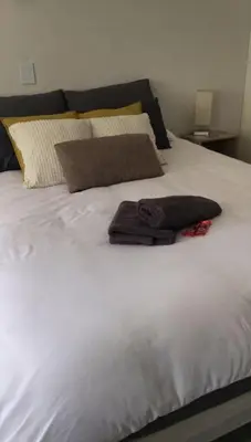 a white bed with two towels on top of it at Relaxing Hideaway in Strand