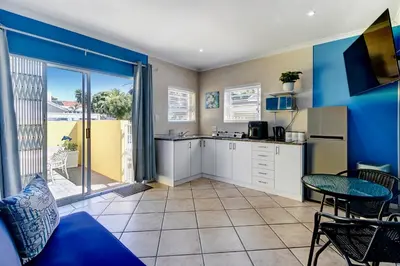 a kitchen with a couch and a table in a room at Sea Breeze Kite Dreams 1 in Cape Town