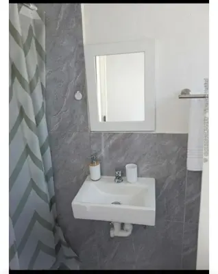 a bathroom with a white sink and a mirror at 60 On Kosmos in Bellville South
