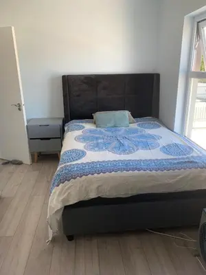 a bedroom with a bed with a blue quilt on it at Cape Town in Cape Town