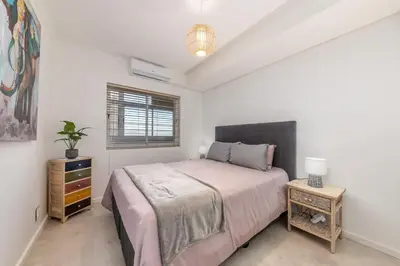 a bedroom with a bed and a table with a lamp at Beautiful 3 bed apartment with sea views Horizon Bay 502 in Cape Town