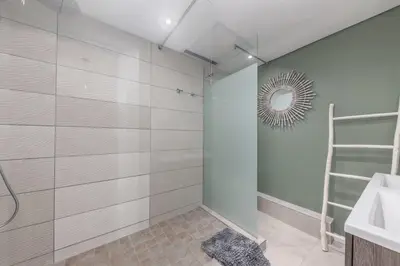 a bathroom with a shower and a sink and a mirror at Beautiful 3 bed apartment with sea views Horizon Bay 502 in Cape Town