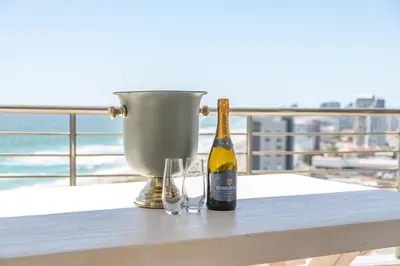 a bottle of champagne and two glasses on a table at Horizon Haven with stunning view by HMH 803 in Cape Town