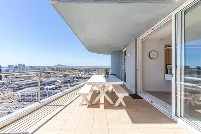 a balcony with a table and a view of a harbor at Horizon Haven with stunning view by HMH 803 in Cape Town