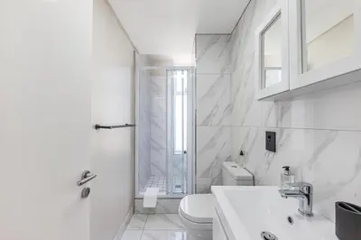 a white bathroom with a toilet and a sink at Horizon Haven with stunning view by HMH 803 in Cape Town