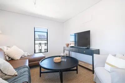 a living room with a couch and a table at 221 Paarl Lux 1 Bdrm Apt with Mountain Views in Paarl