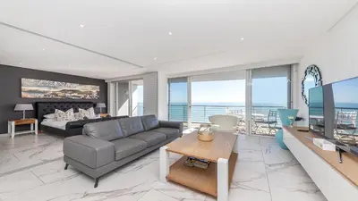 a living room with a couch and a table at Horizon Bay 1302 Loadshedding Free APT by HMH in Cape Town