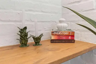 a shelf with two books and two candles on it at Trendy Salt River Loft Apartment in Cape Town